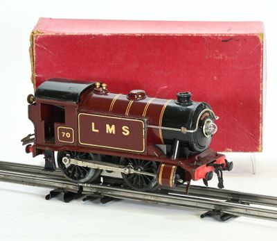 un petit train sur les rails, avec une boîte en arrière-plan