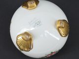 a white box with gold decorations on it on a black surface