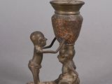bronze figurine of a boy helping a girl with a vase