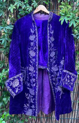 une photo d'une veste violette accrochée à une clôture en bambou