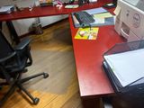 a red desk with a computer and a printer on it