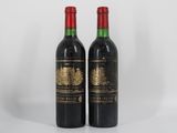deux bouteilles de vin rouge posées l'une à côté de l'autre sur une surface blanche