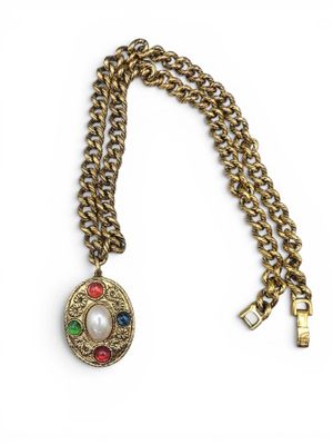 un gros plan d'un collier suspendu à une chaîne sur fond blanc