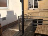 a wooden table and a black umbrella on a balcony