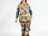 figurine of a man dressed in oriental clothing with a feather on his head