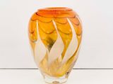 a glass vase that is sitting on a white surface