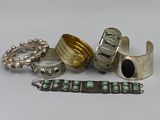 several silver and turquoise rings and bracelets on a white surface