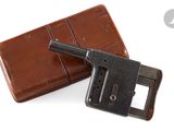 un étui en cuir marron sur lequel est posé un pistolet