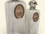 two clear glass bottles with silver lids on a white surface