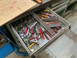 un tiroir rempli d'outils posé par terre