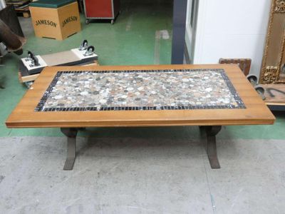a coffee table with a mosaic top on a green floor