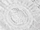 black and white photograph of a glass plate with a face in the center