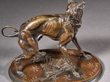 bronze sculpture of a dog on a plate with a fan