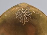 a gold plate with a design on it on a table