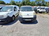 deux petites camionnettes garées l'une à côté de l'autre sur un parking