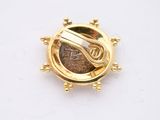 an image of a gold plated brooch with a coin in the center