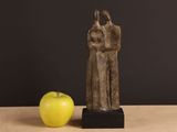 a statue of a man and a woman standing next to an apple