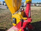 an image of a red and yellow machine that is sitting in the grass