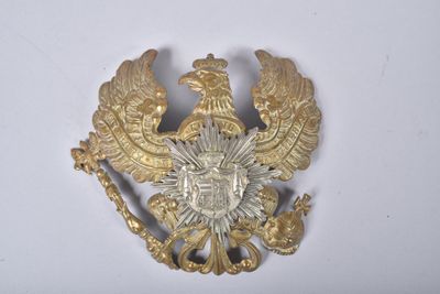 une image représentant une broche de couleur dorée sur laquelle figurent deux oiseaux