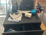 a desk with a laptop and other office supplies on it