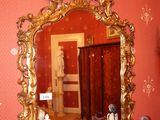 un miroir accroché au mur au-dessus d'une table sur laquelle se trouve un vase