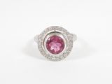 a close up of a pink and white diamond ring on a white surface