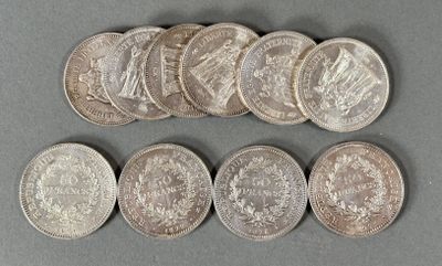 six different types of silver coins on a gray surface