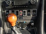 a close up of a car ' s dashboard with a wooden gear stick