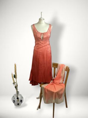 a dress on a mannequin stand next to a chair