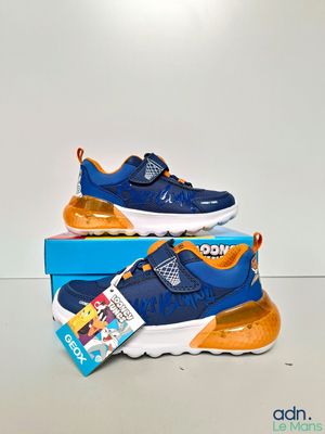 a pair of children ' s shoes in a box on a white surface