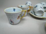 several cups and saucers are lined up on a table