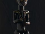 une statue noire et dorée représentant un homme tenant une guitare
