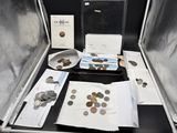 une valise remplie de pièces de monnaie et d'autres objets posée sur une table