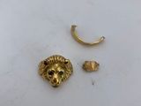 a close up of a gold earring with a lion head on it