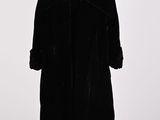 a black coat on a mannequin stand with a white background