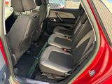 the back seats of a red car are empty in a parking lot