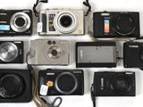 de nombreux modèles d'appareils photo numériques disposés sur la table