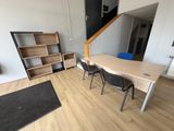 une table et des chaises dans une pièce où se trouve une bibliothèque