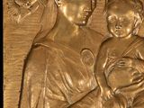 brass relief of a woman holding a baby in her arms