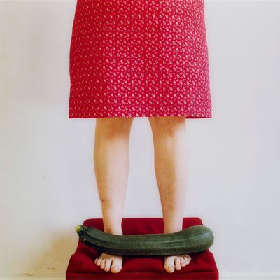 a woman standing on a scale with a cucumber in her hand