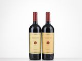 two bottles of red wine sitting on top of a table