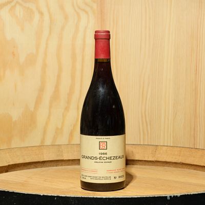 a bottle of wine sitting on top of a barrel