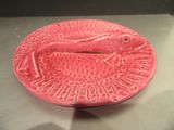 une assiette rose avec un poisson dessiné dessus, posée sur une table