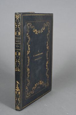 an old book sitting on top of a table next to a white wall