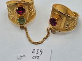two gold rings with garnets on a chain