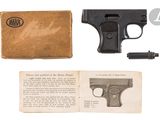 a gun and a book on a white surface