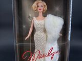 the barbie doll is in a box with a fur stoler