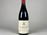 a bottle of red wine sitting on top of a white table