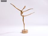 une statue en or représentant une femme les bras tendus