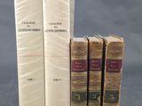 trois livres sont empilés sur une table